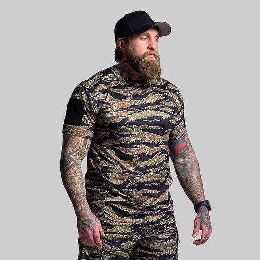Man wearing a camouflage t-shirt and cap on a gray background