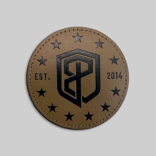 Round leather patch with a black logo and stars on a gray background