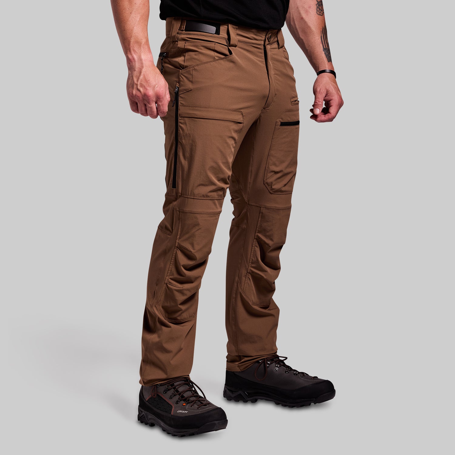 Brown outdoor pants worn by a person on a gray background