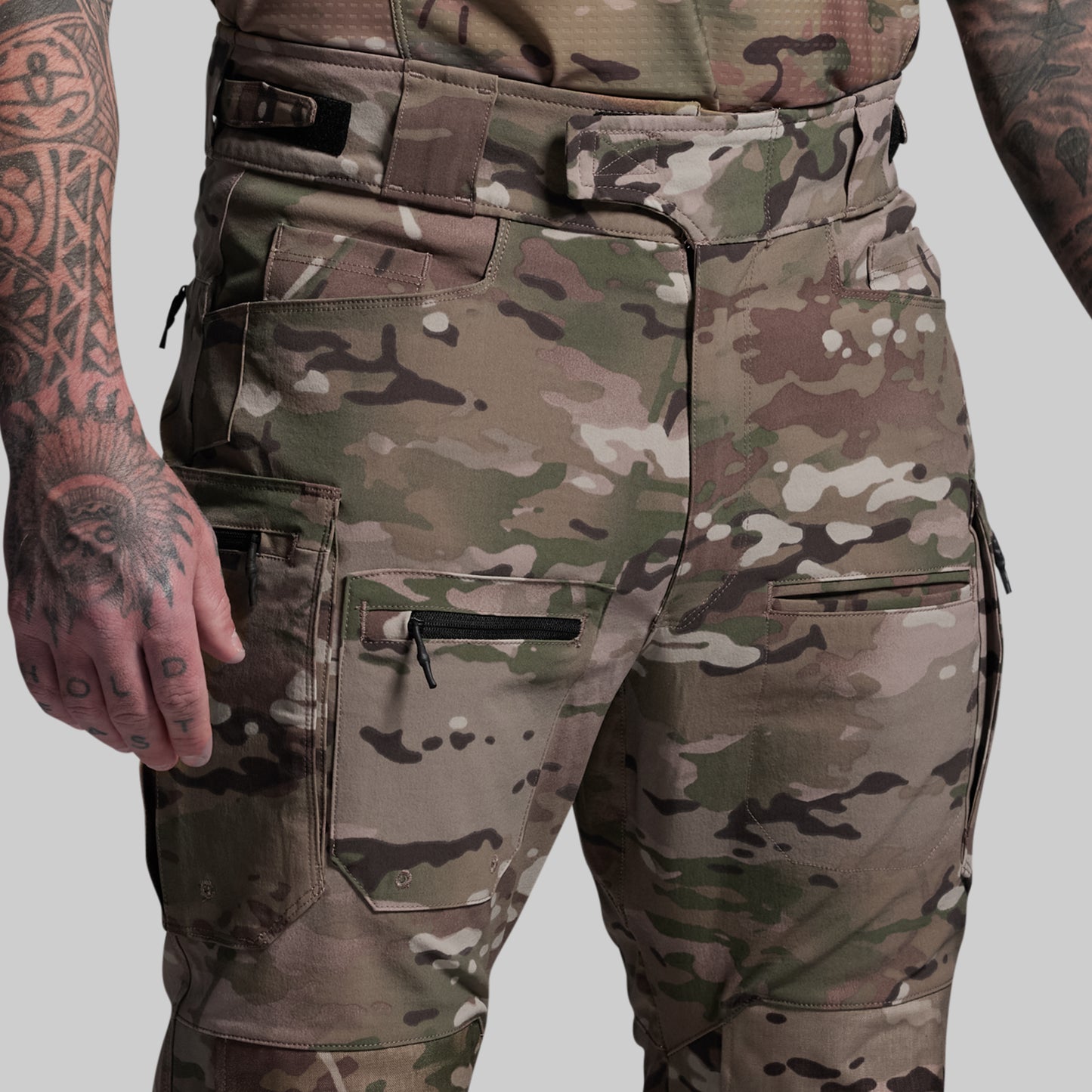 Camouflage pants with multiple pockets on a plain background