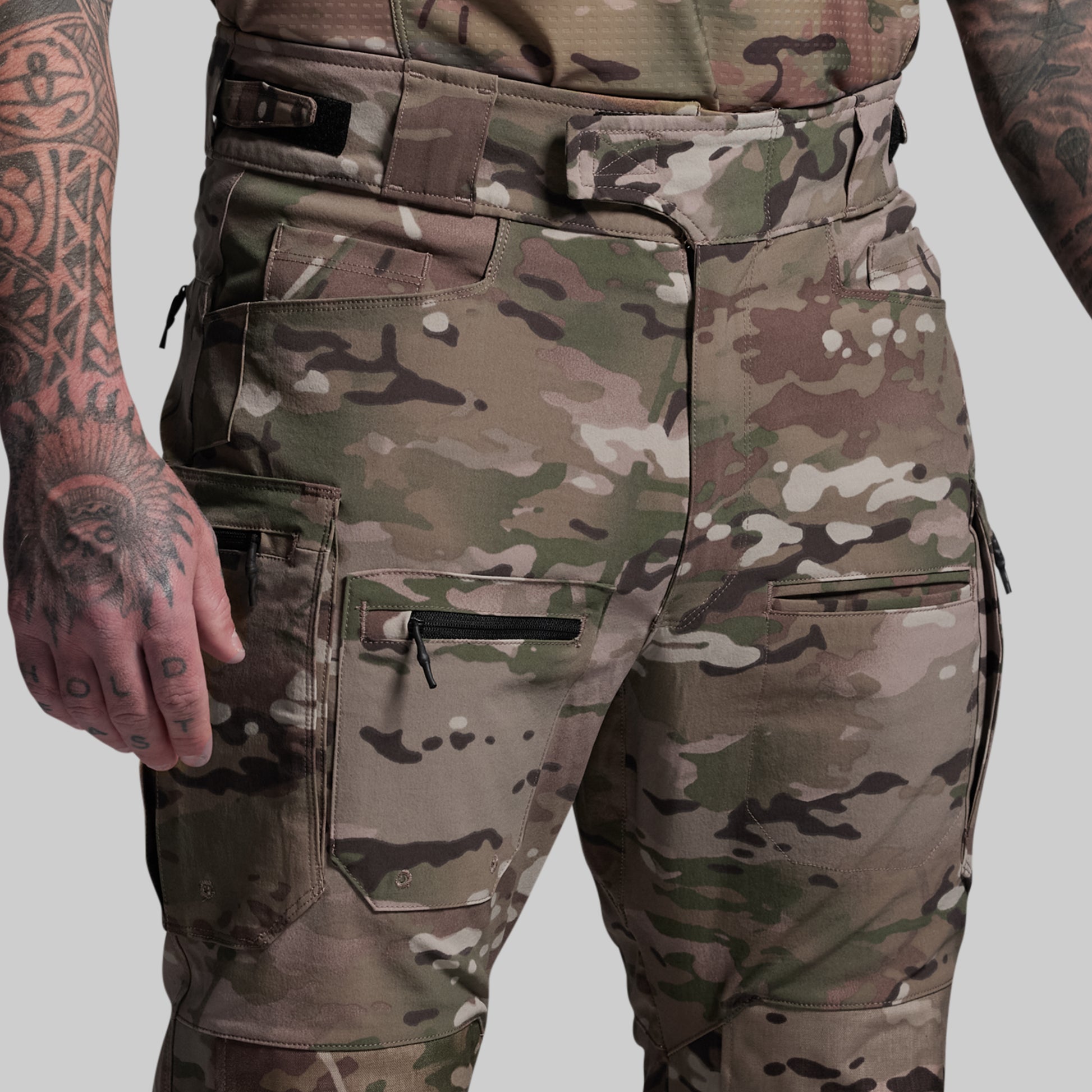 Camouflage pants with multiple pockets on a plain background