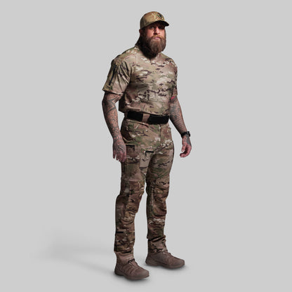 Person wearing a full camouflage outfit with a cap on a gray background