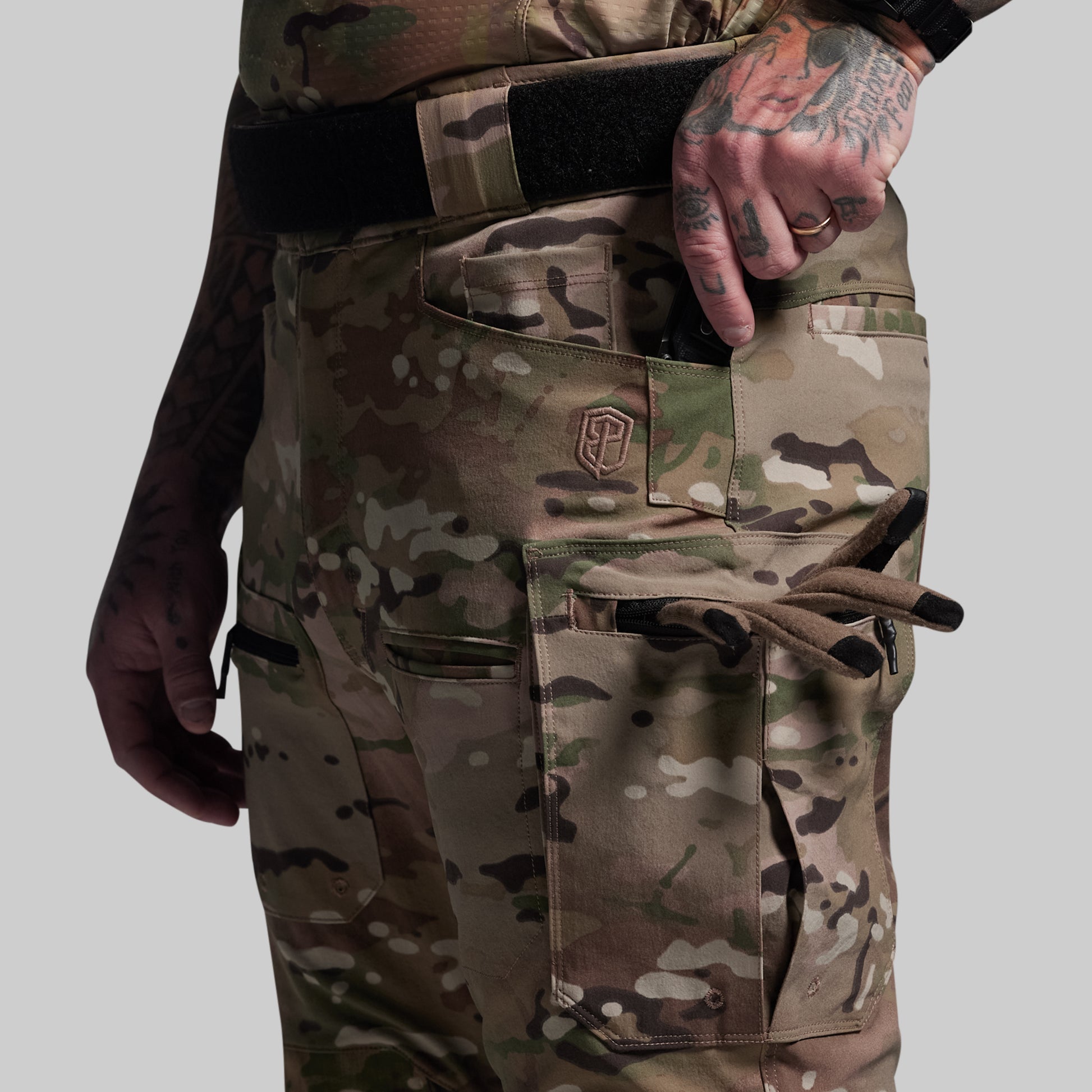 Camouflage pants with a visible brand logo on a gray background