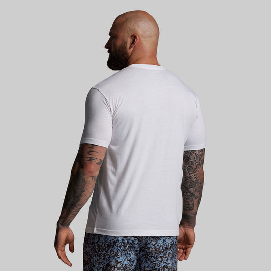 Man wearing a white t-shirt and patterned shorts on a plain background