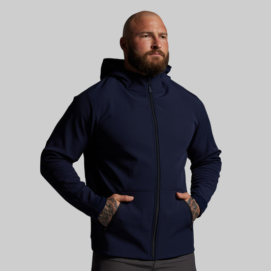 Man wearing a navy blue hoodie against a gray background