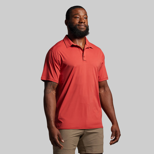 Man wearing a red polo shirt against a gray background
