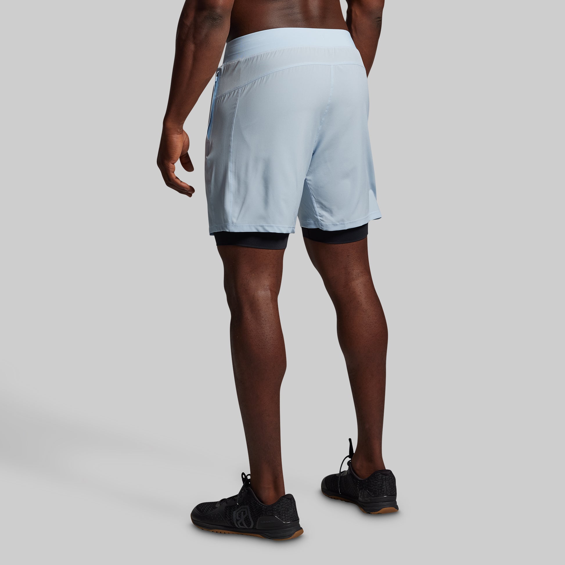 Person wearing light blue athletic shorts on a plain background