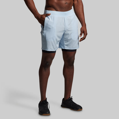Person wearing light blue shorts on a plain background