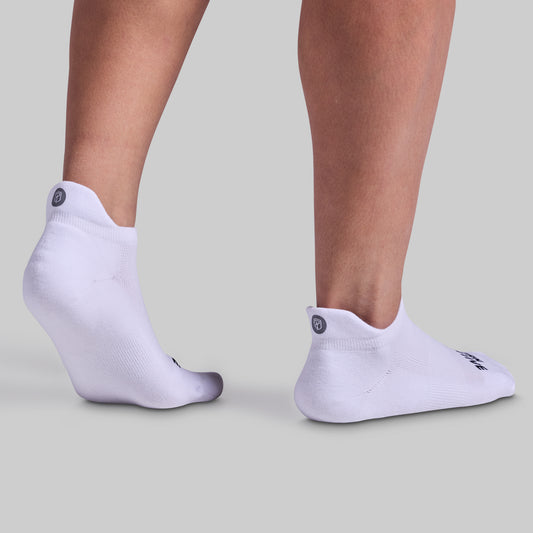 A pair of white performance ankle socks designed for training sessions and everyday wear, featuring cushioned panels and breathable fabric.