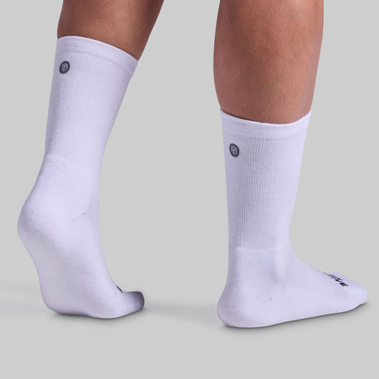 A pair of white performance crew socks with cushioned panels, displayed on a model's legs.