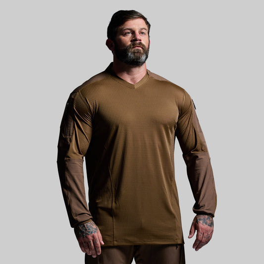 Man wearing a brown tactical shirt on a gray background