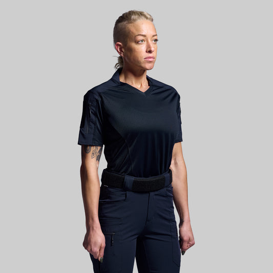 Person wearing a blue tactical outfit with a belt on a gray background