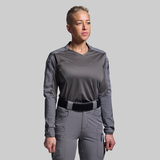 Person wearing a gray tactical outfit on a plain background