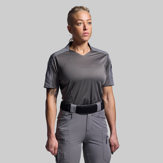 Person wearing a gray tactical outfit on a plain background