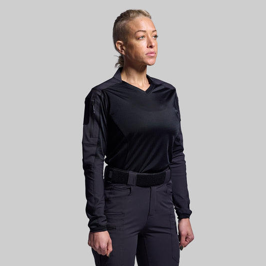 Person wearing a black long-sleeve shirt and pants on a gray background
