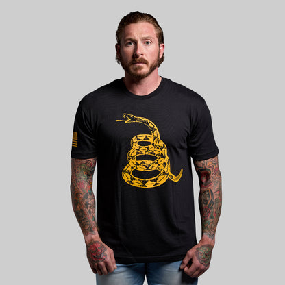 Man wearing a black t-shirt with a yellow snake design on a gray background