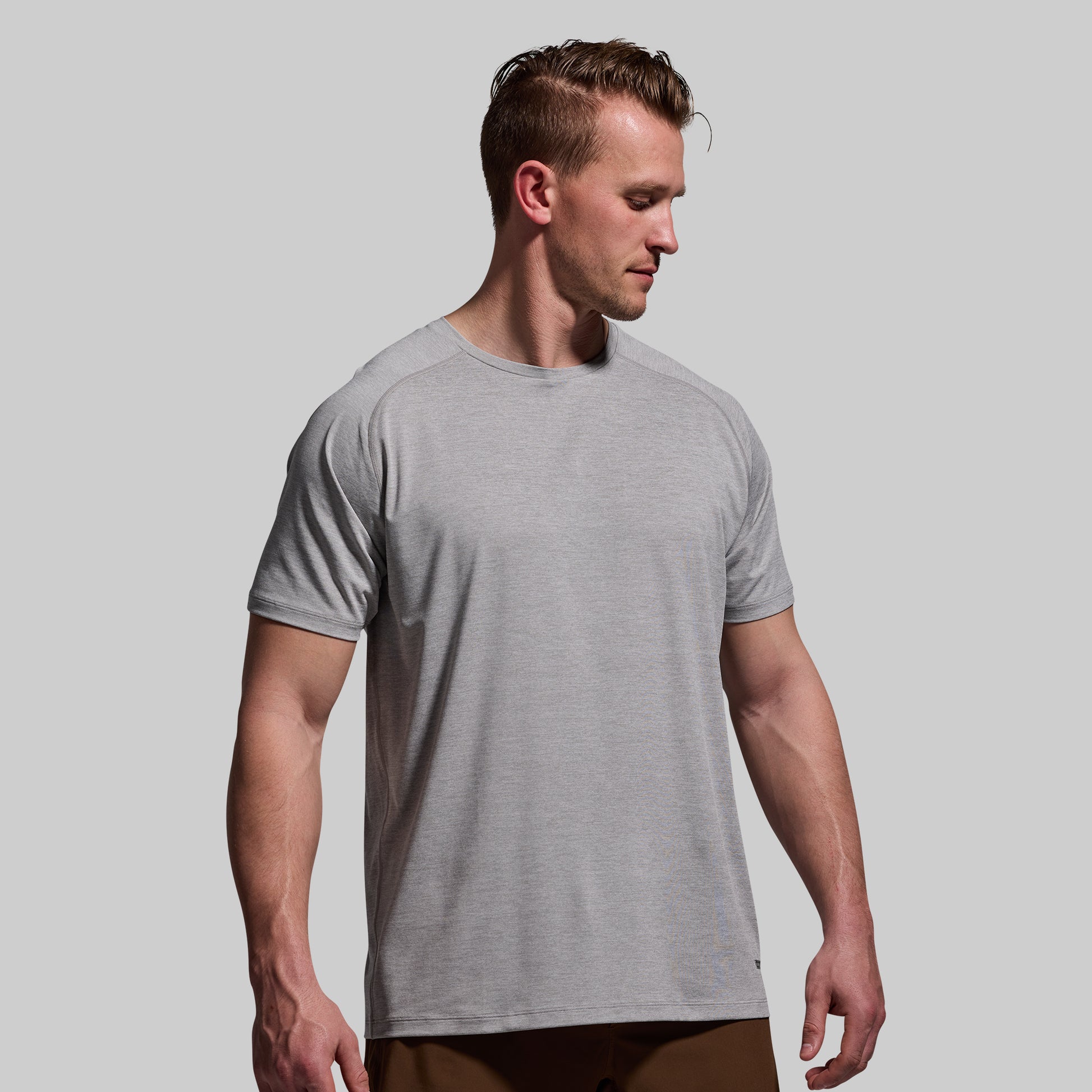 Man wearing a gray t-shirt against a plain background