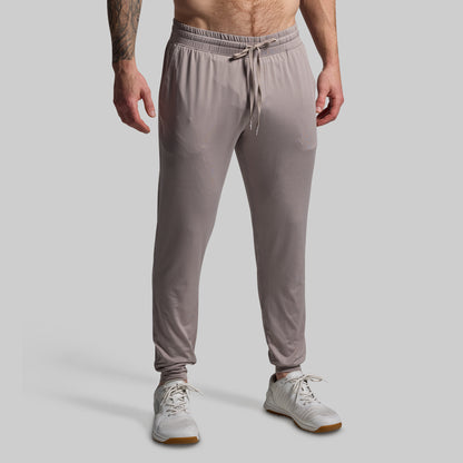 Person wearing light gray jogger pants on a plain background