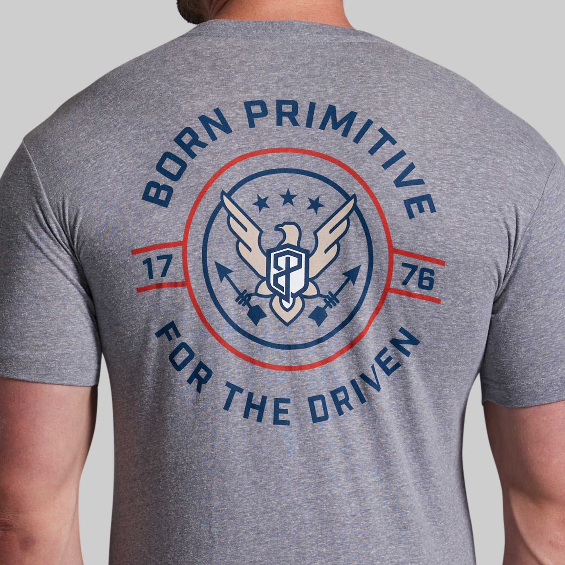 Gray t-shirt with 'Born Primitive' logo and text on the back