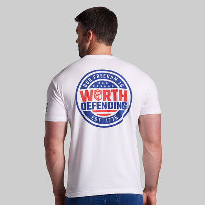 Man wearing a white t-shirt with a patriotic design on the back against a gray background