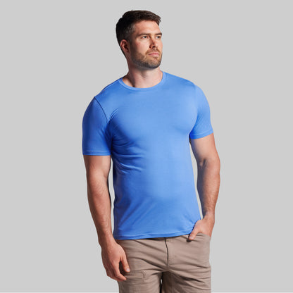 Man wearing a blue t-shirt against a gray background