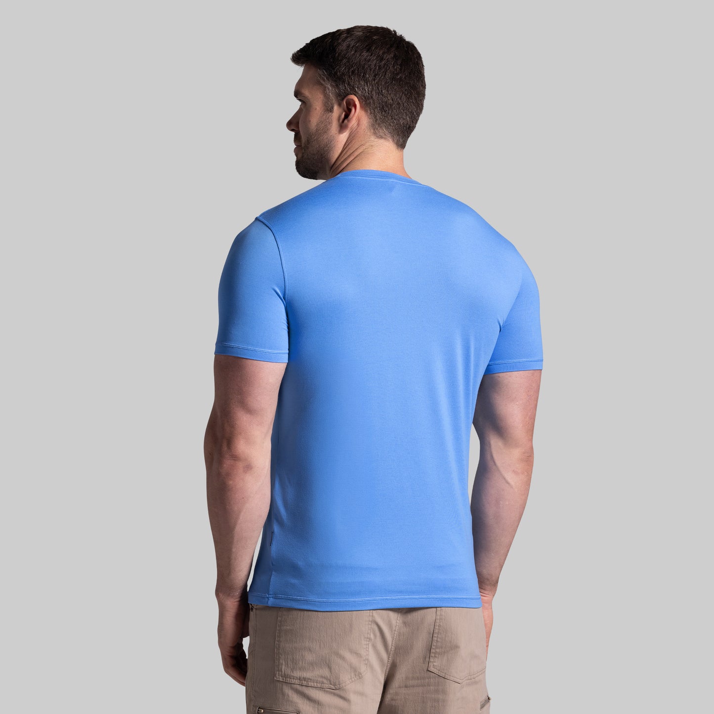 Man wearing a blue t-shirt on a gray background