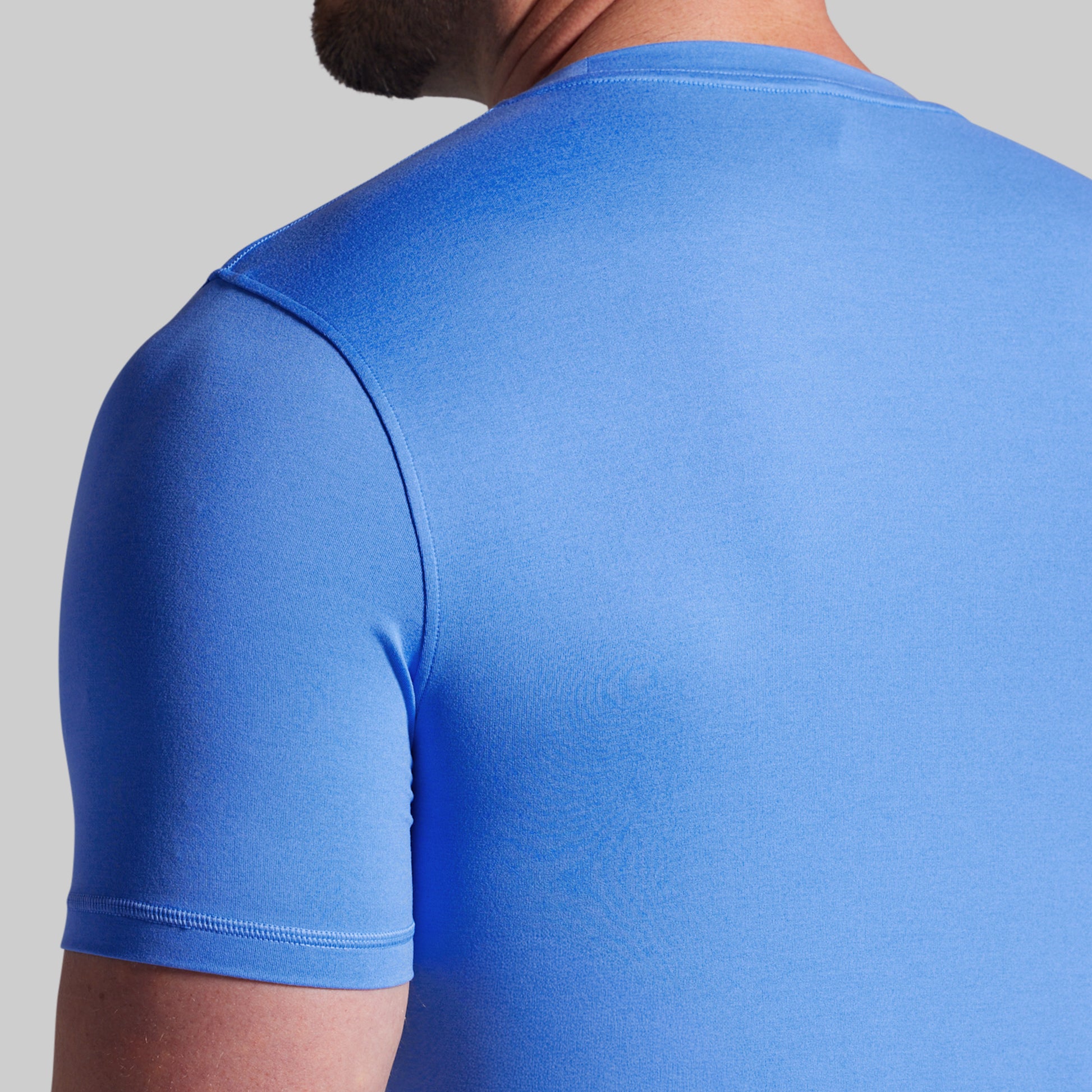 Blue t-shirt worn by a person on a gray background