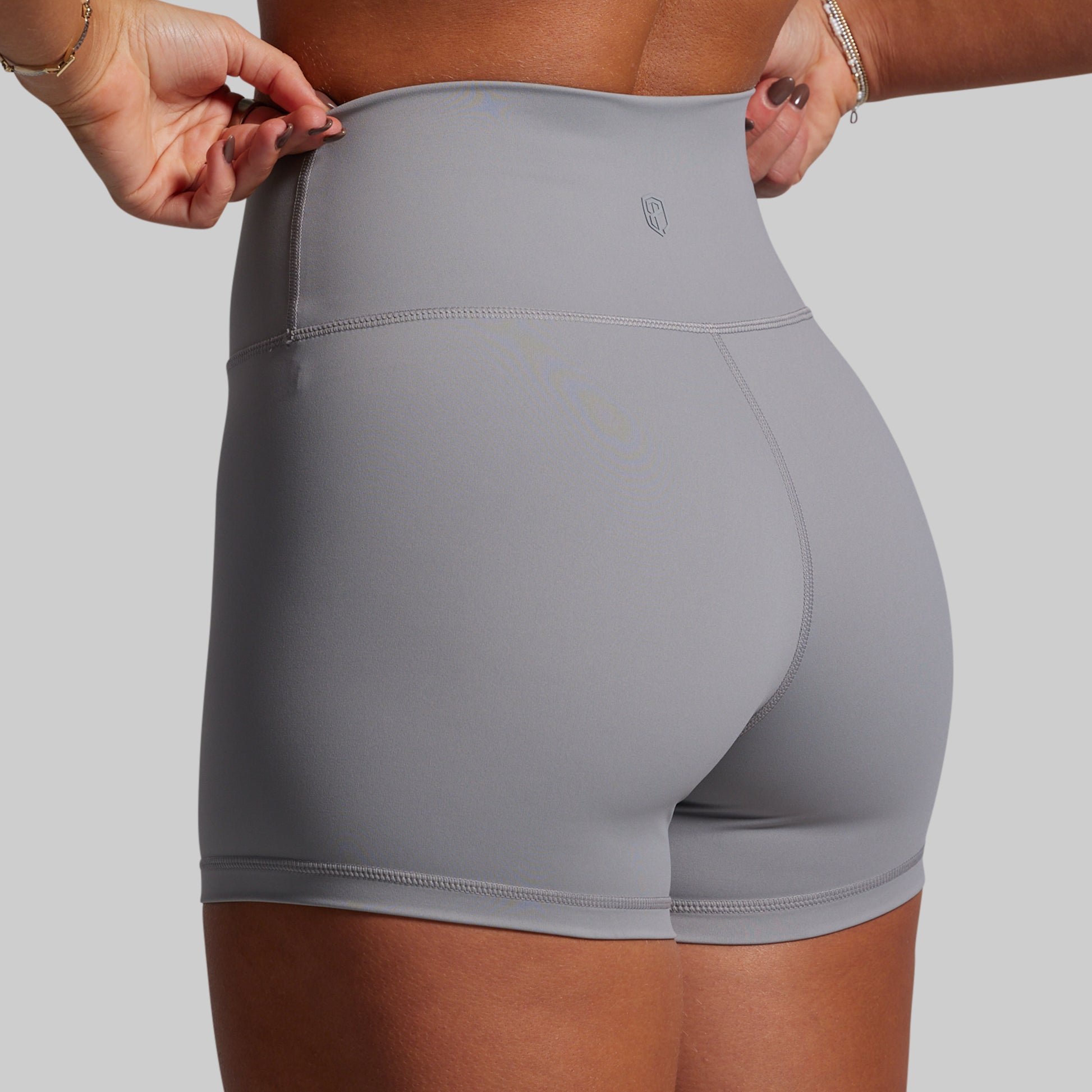 Person wearing gray athletic shorts on a plain background