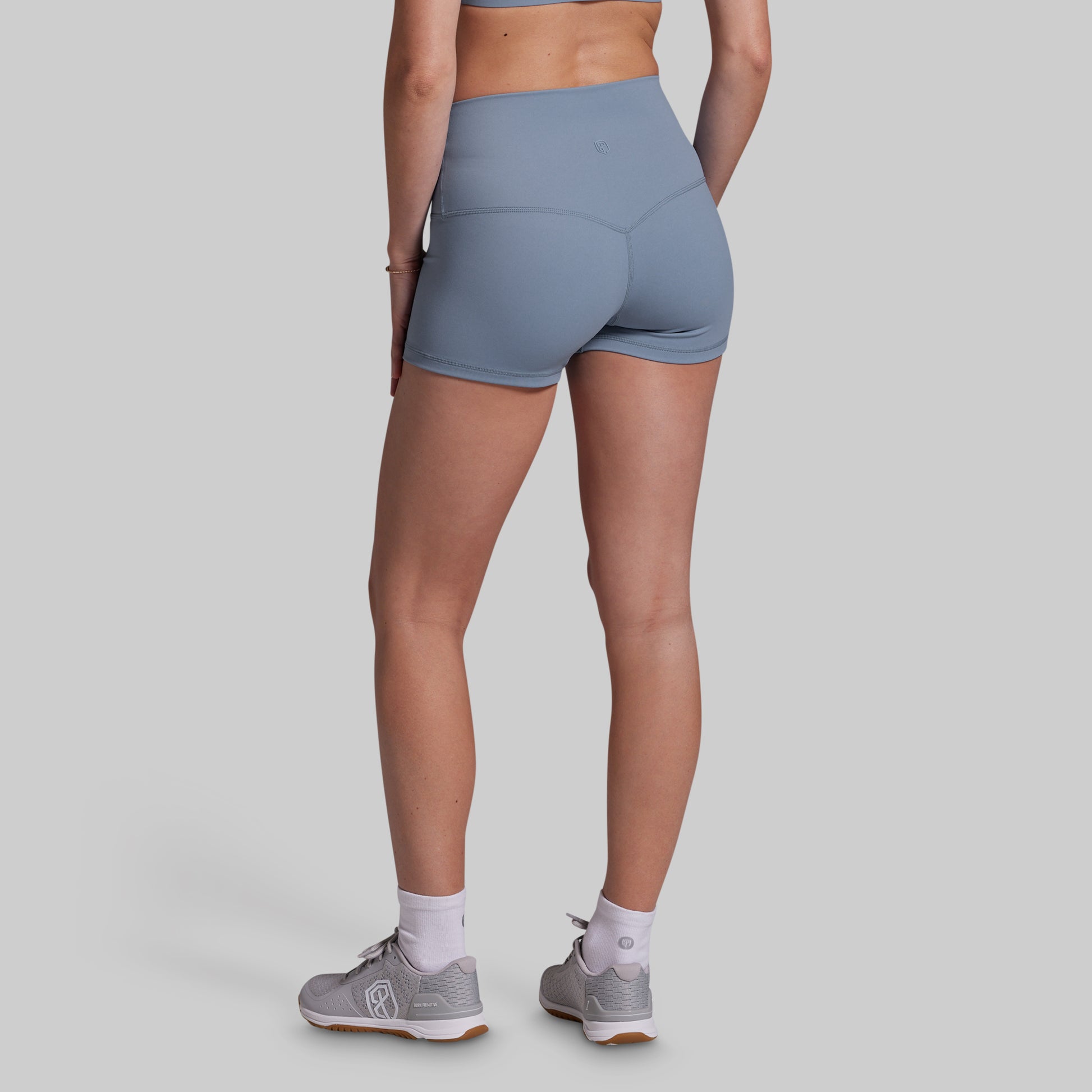 Person wearing gray athletic shorts on a plain background