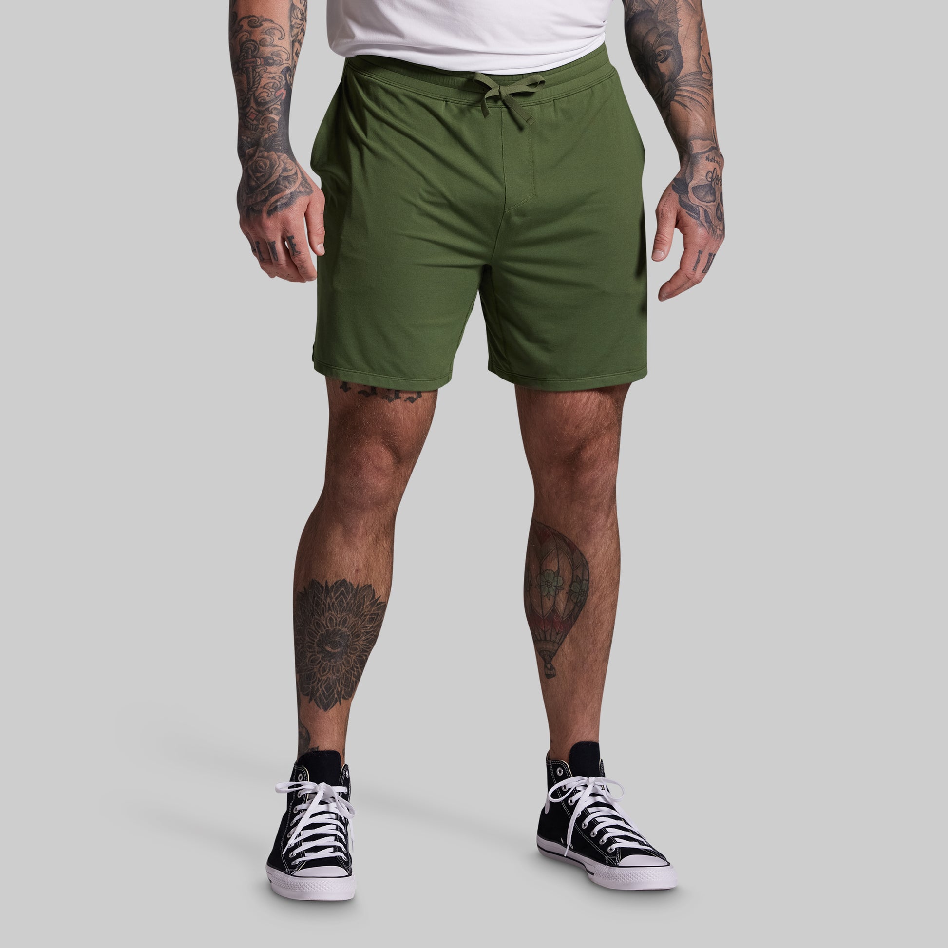 Person wearing green shorts on a gray background