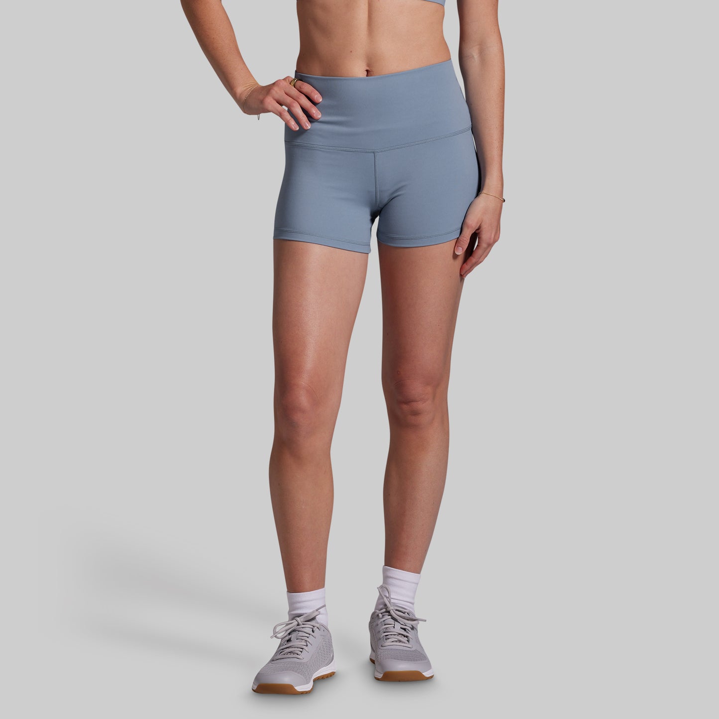 Person wearing light blue athletic shorts on a gray background