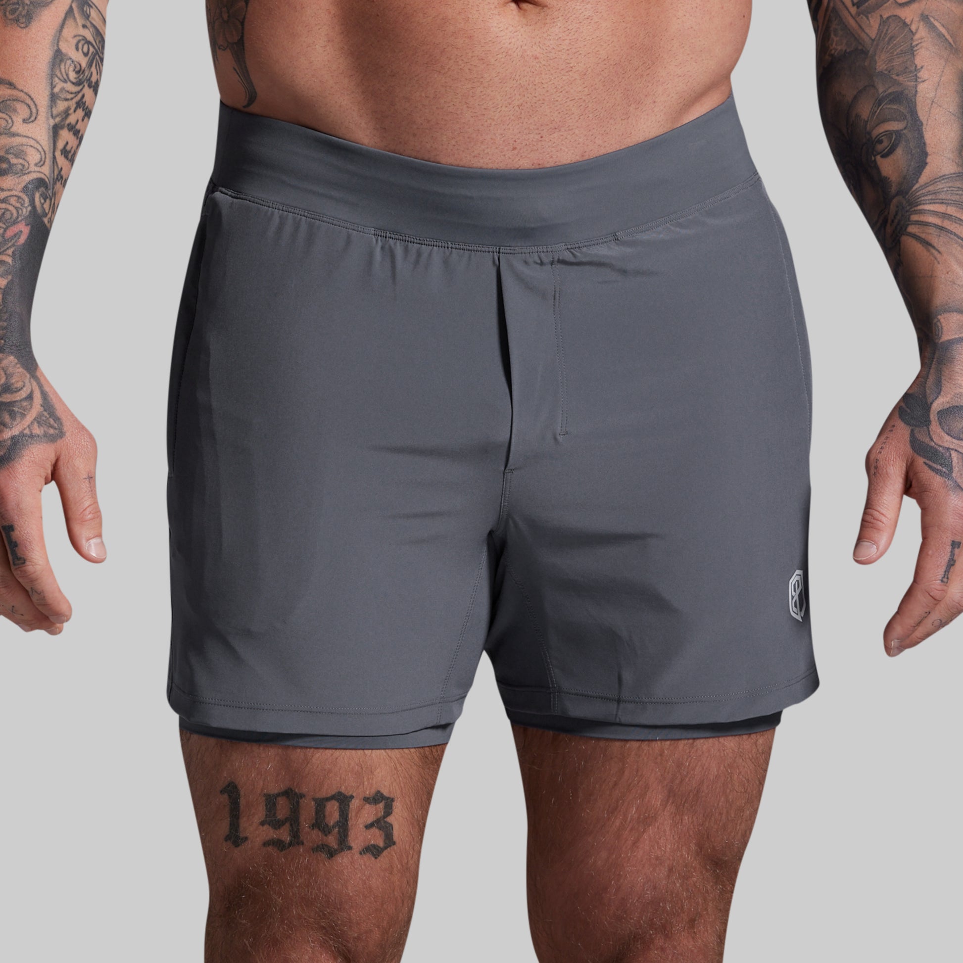 Person wearing gray athletic shorts on a plain background