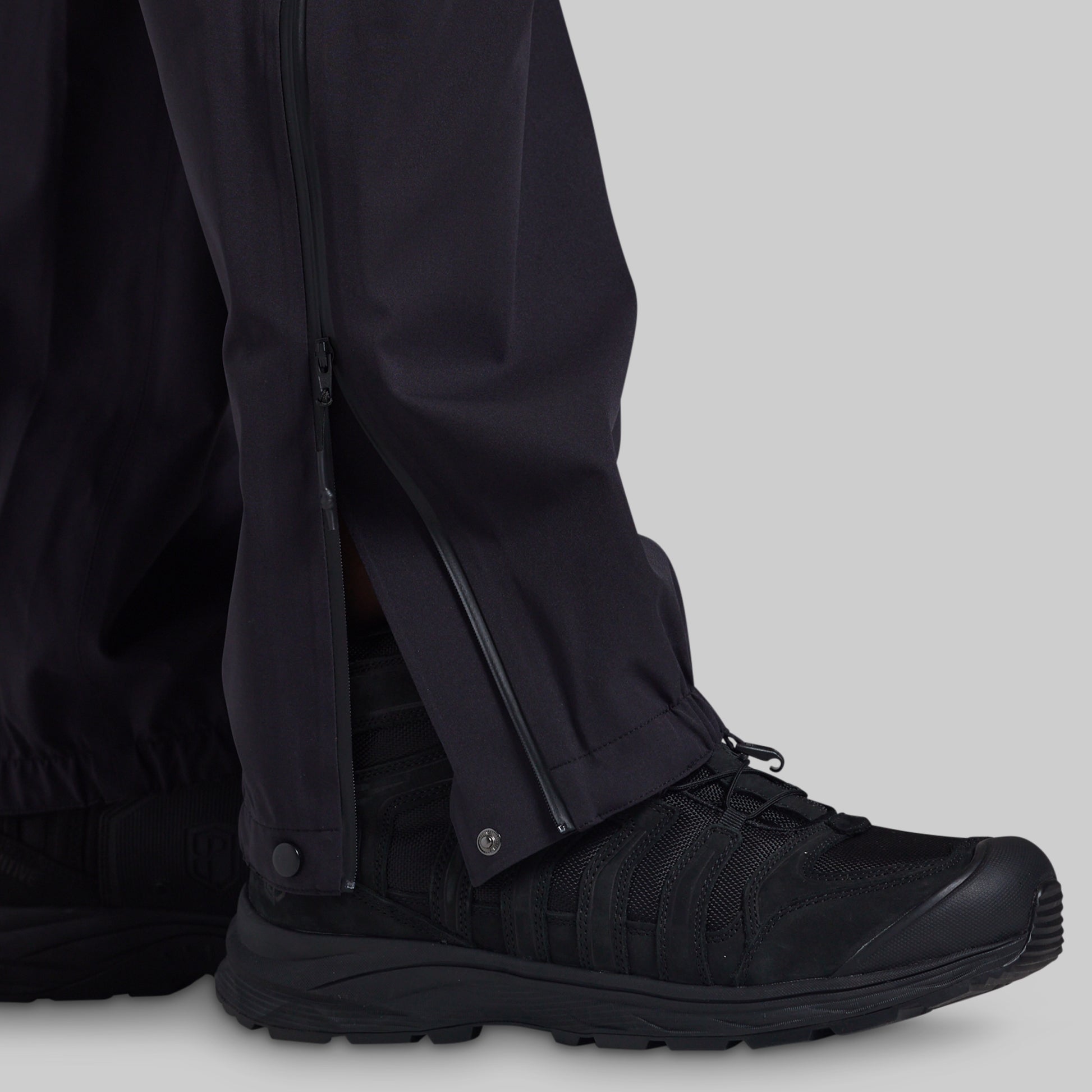 Full-length side zipper open over a boot on black Mission FLEX Rain Pant 2.0