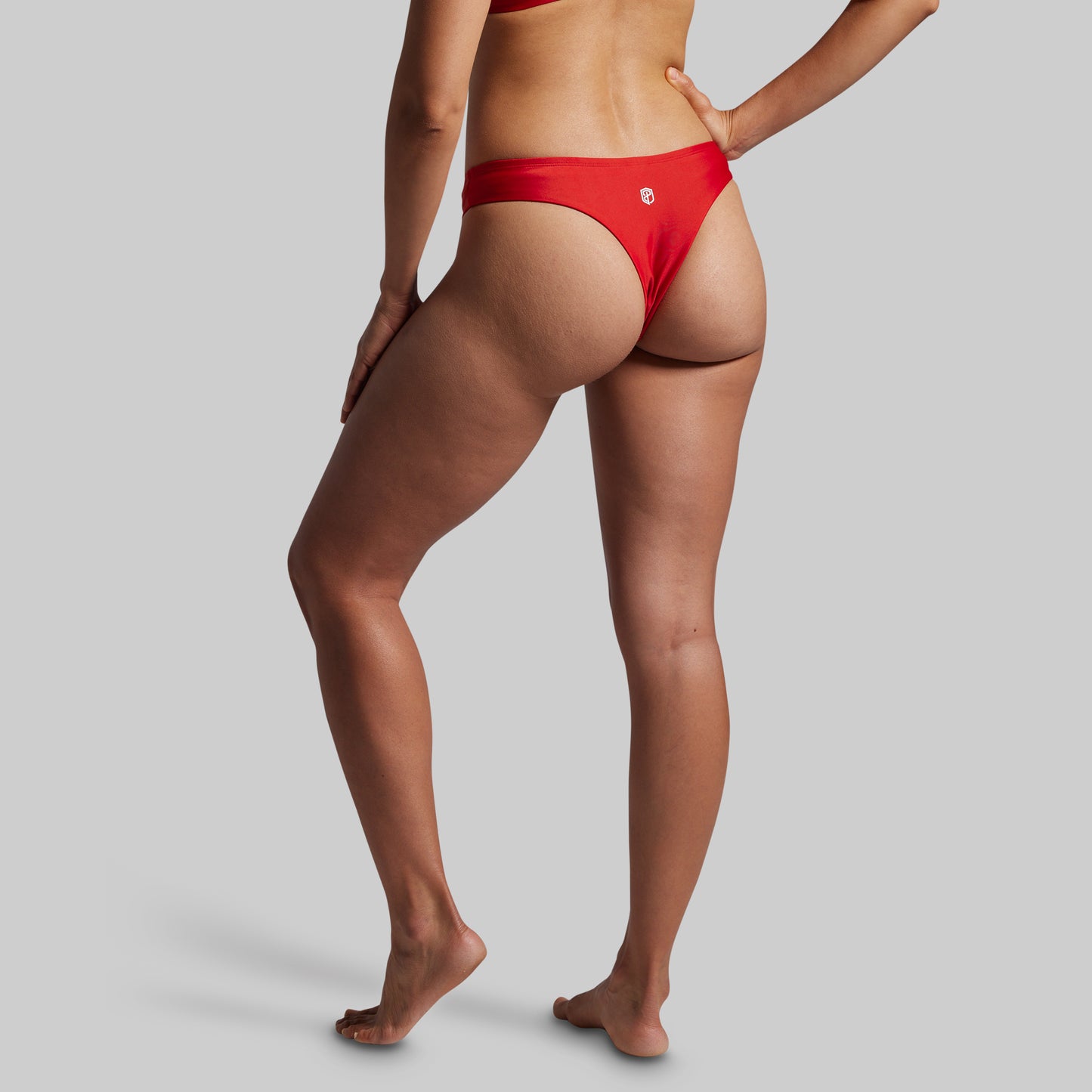 Person wearing red bikini bottoms on a plain background