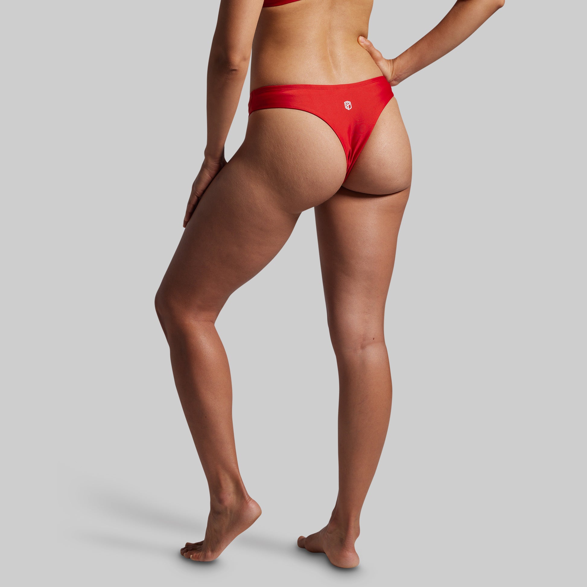 Person wearing red bikini bottoms on a plain background
