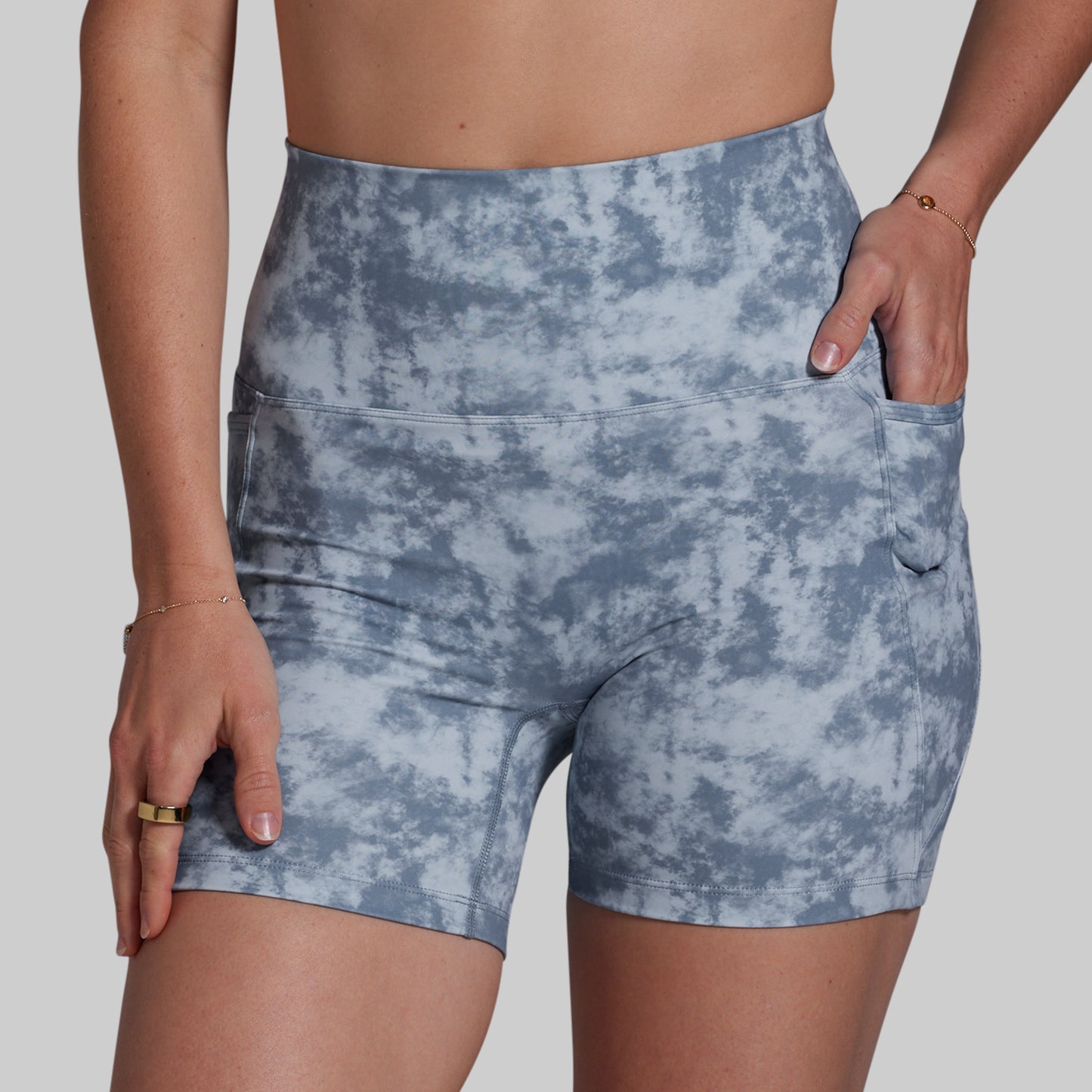 Blue tie-dye shorts worn by a person on a plain background