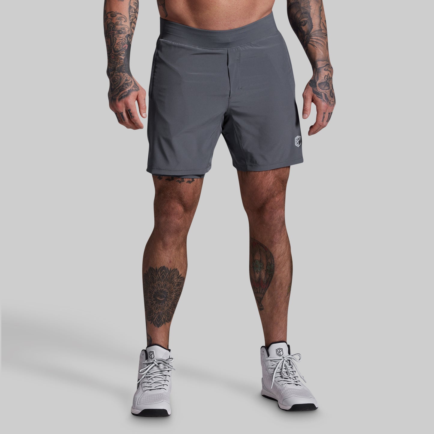 Person wearing gray athletic shorts on a plain background