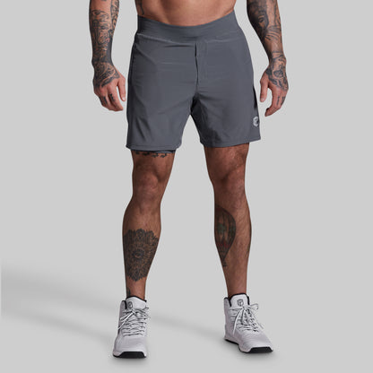 Person wearing gray athletic shorts on a plain background