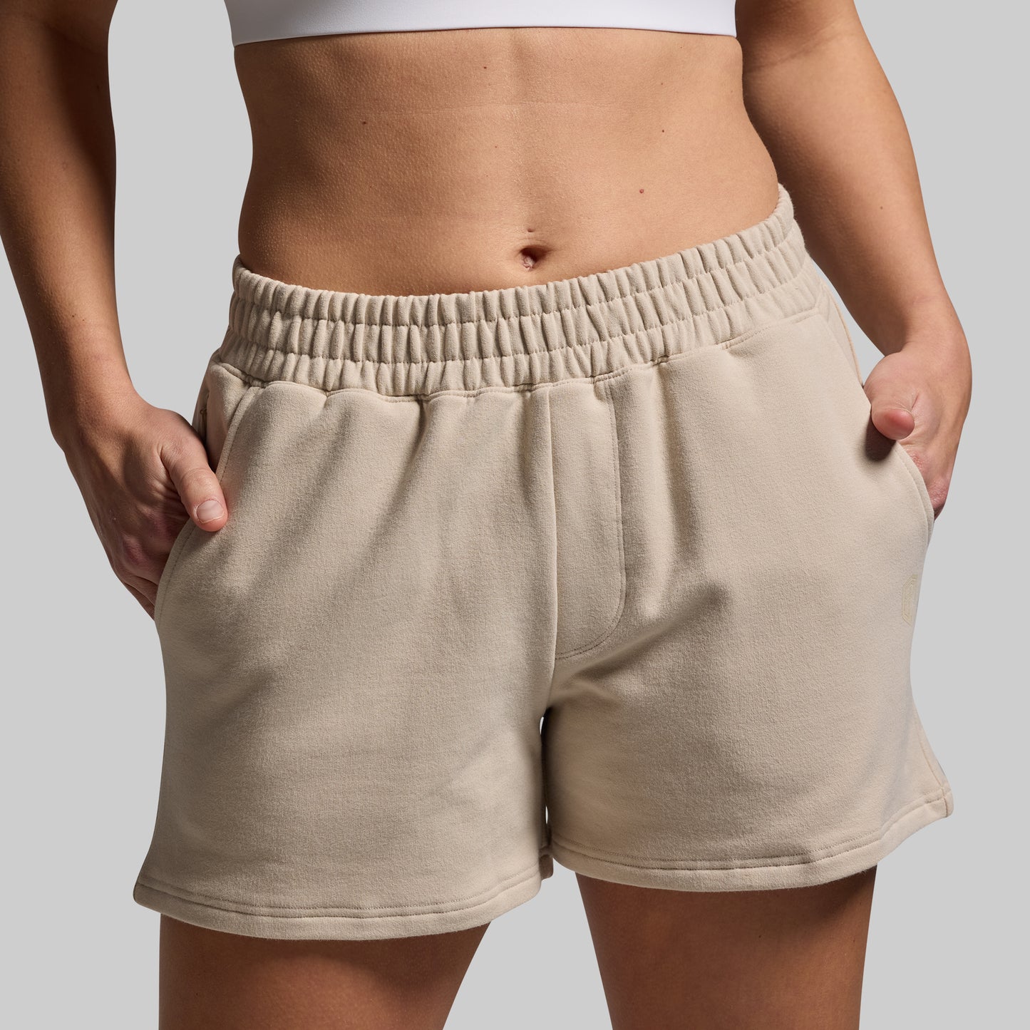 Beige shorts worn by a person on a plain background