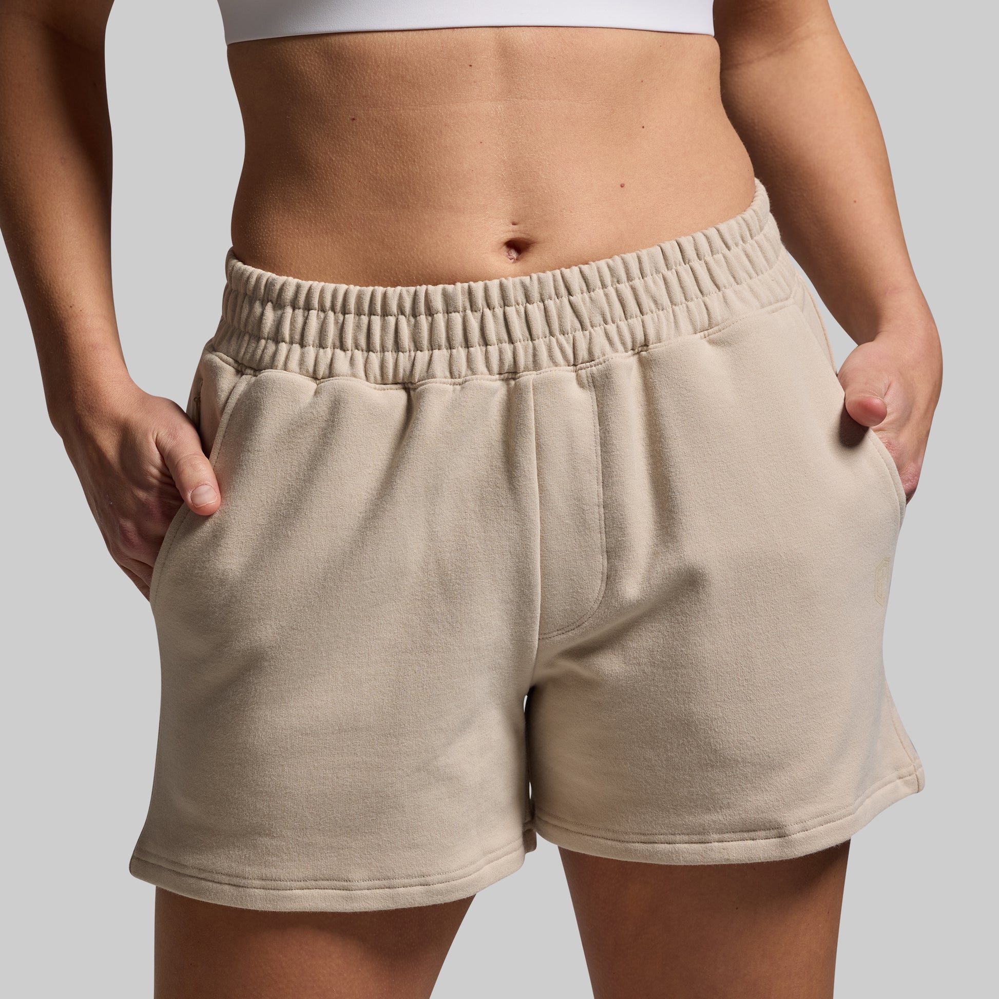 Beige shorts worn by a person on a plain background