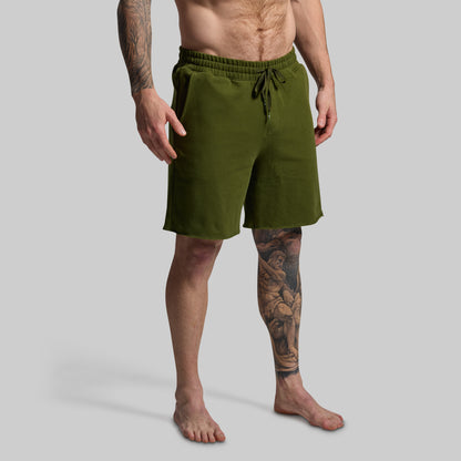 Man wearing green shorts on a gray background