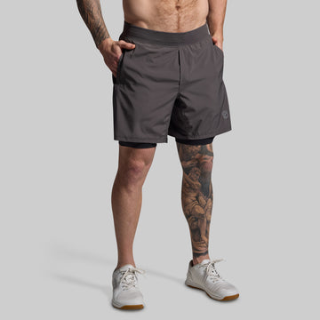 Person wearing gray athletic shorts on a plain background