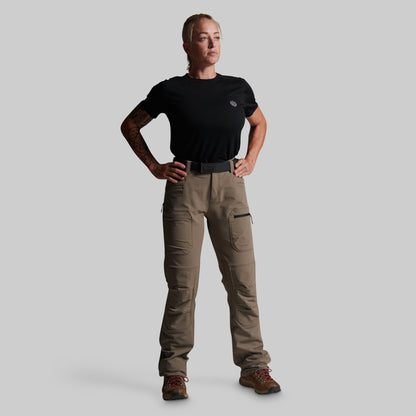 A woman modeling a black short-sleeve t-shirt and high-waisted grey cargo pants with a black belt, standing against a solid gray background.