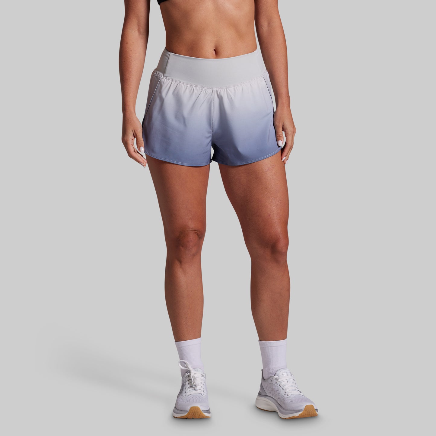 Person wearing gray athletic shorts on a gray background
