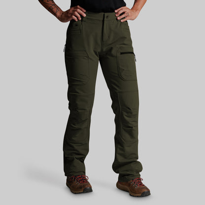 A person wearing dark olive green cargo pants with brown hiking boots, shown from the waist down against a light gray studio background.