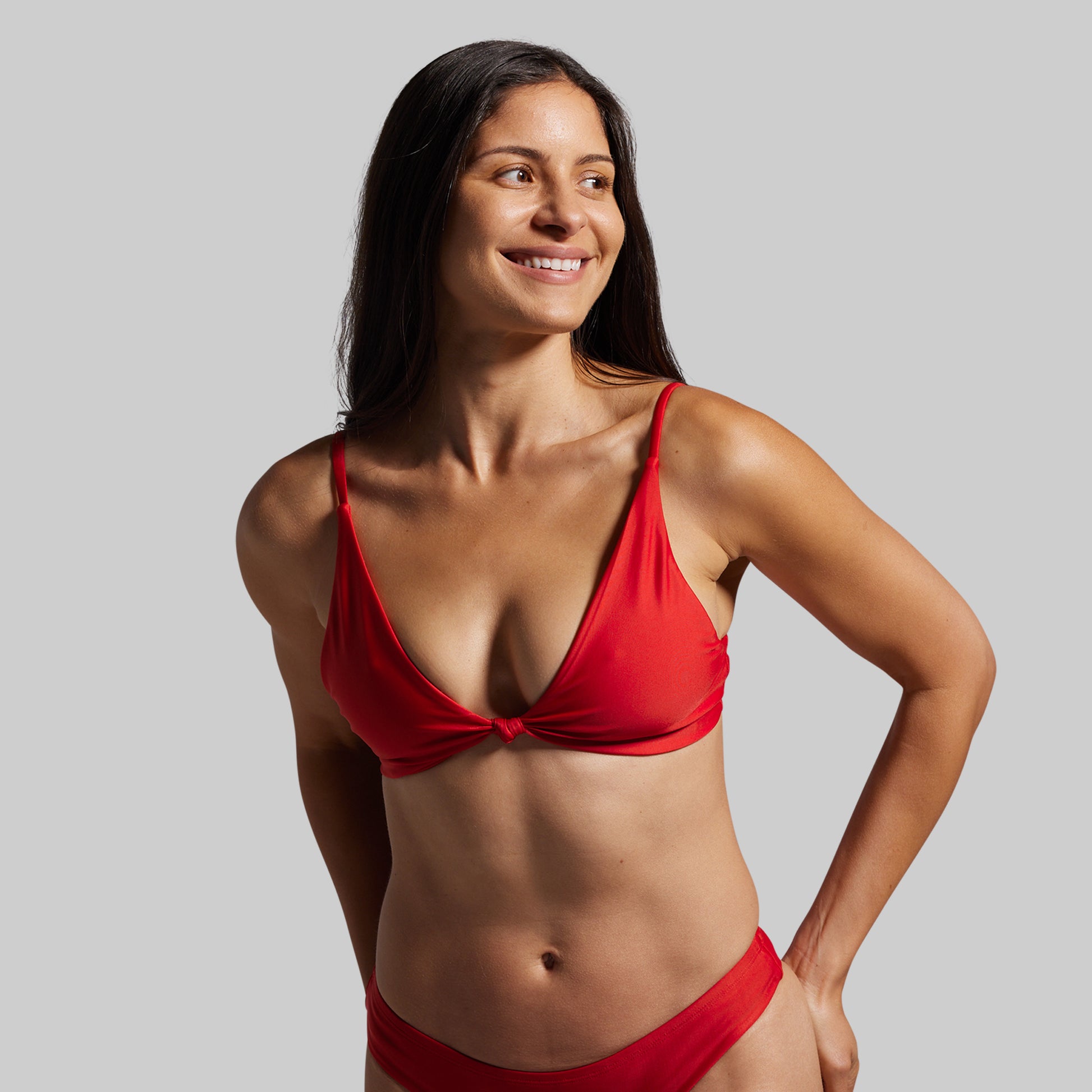 Woman wearing a red bikini against a gray background