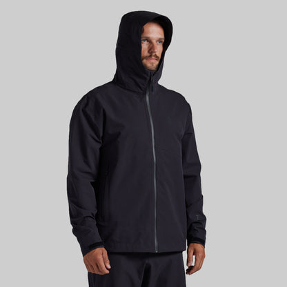 Man wearing the black Mission FLEX Rain Jacket 2.0, front view with hood up