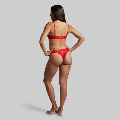 Woman wearing a red bikini on a gray background