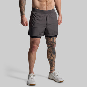 Man wearing gray athletic shorts on a plain background