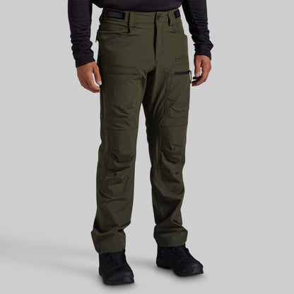 A person wearing olive green outdoor cargo pants with a black long-sleeve shirt and black boots, shown from the waist down against a light gray studio background.
